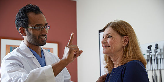 A doctor holds up a finger to assess a patient's progress following a stroke